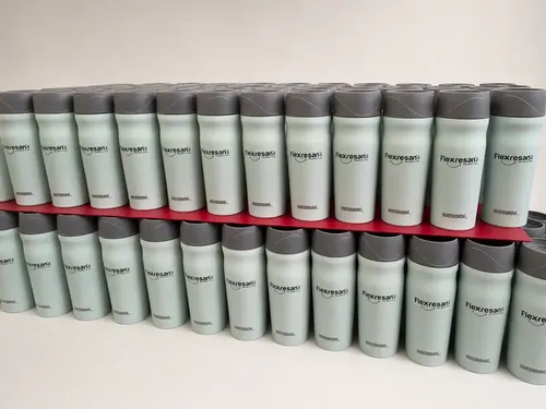 Fila de vasos térmicos verdes con tapa negra y el logo de Flexresan